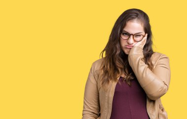 Artı boyutu genç kadın güzel izole arka plan düşünme bakmaktan bir elbise ve deri ceket giyiyor ve yorgun sıkılmış çapraz silah depresyon sorunları ile.