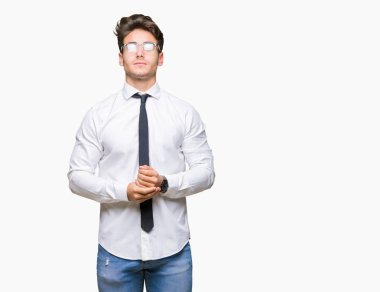 Arka plan eller birlikte üzerinde gözlük takan genç iş adamı izole ve rahat ve neşeli gülümseyen parmak çarpı işareti. Başarı ve iyimser