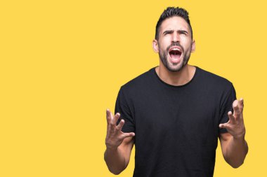 Genç yakışıklı adam izole arka plan çılgın ve kızgın bağırarak ve agresif ifade ve silah kaldırdı bağırıyor. Hayal kırıklığı kavramı.