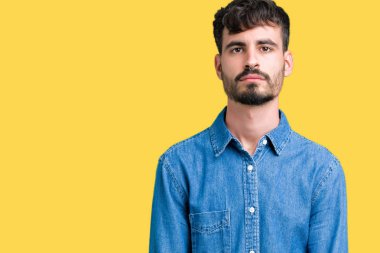 İzole arka plan gevşek yüzünde ciddi bir ifade ile genç yakışıklı adam. Basit ve doğal kameraya bakıyor.