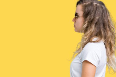 Güzel sarışın genç kadın giyiyor güneş gözlüğü izole arka tarafına, seyir üzerinde dinlenmek doğal yüz emin gülümseme ile pozuyla profili.