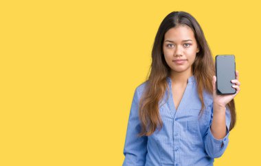 Genç güzel esmer iş kadın gösteren ekran smartphone acımak yüz ciddi düşünüyorum üstünde kendine güvenen bir ifade ile izole arka plan üzerinde