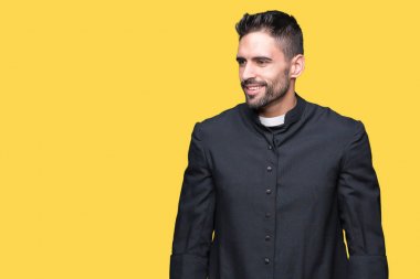 Izole arka plan üzerinde Genç Hıristiyan rahip yüzünde gülümseme, doğal ifade ile yan bakıyor. Gülmekten emin.