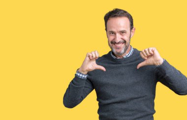 Yüzünde gülümseme ile kendinden emin görünüyorsun, kendini gururlu ve mutlu parmakları ile işaret izole arka plan üzerinde bir kazak giyen yakışıklı orta yaş üst düzey adam.