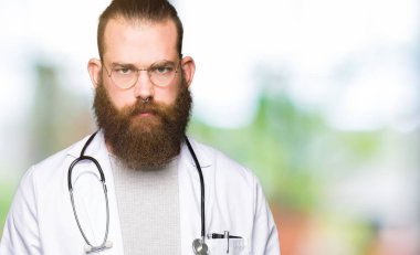 Sakalı ile genç sarışın doktor adam tıbbi ceket şüpheci ve sinir, sorun nedeniyle üzgün çatık giyiyor. Negatif kişi.