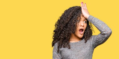 Kıvırcık saçlı, gri süveter giyen genç ve güzel bir kadın. Unuttum, kötü hafıza konsepti.