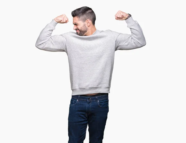 年轻英俊的男子穿着运动衫在孤立的背景显示手臂肌肉微笑自豪 健身理念 — 图库照片