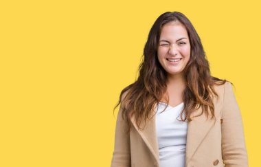 Artı boyutu genç kadın güzel üzerinde kış palto giyiyor arka plan seksi bir ifadeyle, neşeli ve mutlu yüzünü kameraya bakarak göz kırpıyor izole.