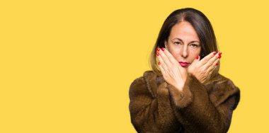 Vizon ceket giyen güzel orta yaş zarif kadın ret ifadesi geçiş silah ve avuç içi negatif işareti, öfkeli yüz yapıyor