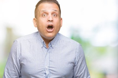 Orta yaş Arap iş adamı izole arka plan korkuyor ve şok sürpriz ifade, korku ve heyecan yüz üzerinden.