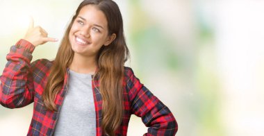 İşin gülümseyen izole arka plan üzerinde bir ceket giyen genç güzel esmer kadın telefon hareketi ile el ve parmak telefonda konuşuyor gibi. Kavramları iletişim.