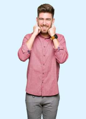 Genç yakışıklı iş casual adam yüksek sesle müzik gürültü rahatsız ifade parmaklarıyla kulaklarıyla kapsayan. Sağır kavramı.