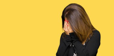 Güzel orta yaş kadın ağlıyor iken eller ile yüz kapsayan üzücü ifade ile kaya ve rulo kazak giyiyor. Depresyon konsepti.