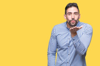 Yakışıklı delikanlı bir öpücük el ile güzel ve seksi olmak hava üfleme kamera bakarak izole arka plan üzerinde. Aşk ifade.