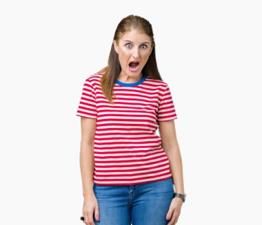 Orta yaş Olgun kadın rahat giyen şüpheci ve alaycı, t-shirt üzerine şok karşısında izole arka plan açık ağız ile şaşırttı.
