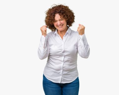 Gülümseyen ve başarı için çığlık güzel orta ager üst düzey businees kadın izole arka plan çok mutlu ve heyecanlı kaldırdı, silah ile kazanan jest yapıyor. Kutlama kavramı.