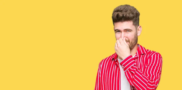 Joven Hombre Guapo Con Camisa Roja Oliendo Algo Apestoso Asqueroso —  Fotos de Stock