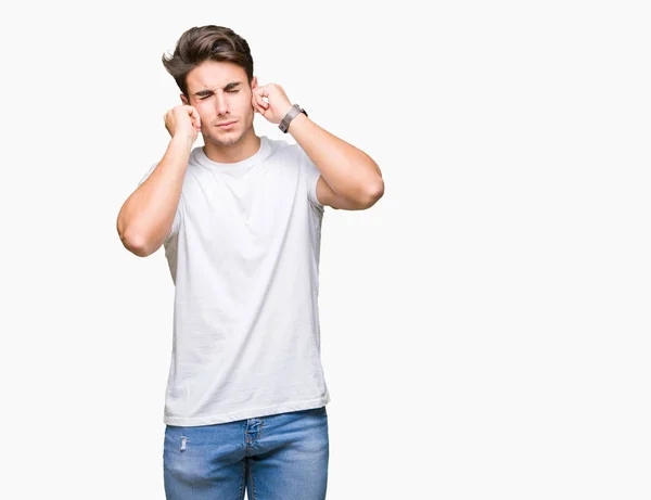 Mladý Pohledný Muž Sobě Bílé Tričko Izolované Pozadí Pokrývající Uši — Stock fotografie