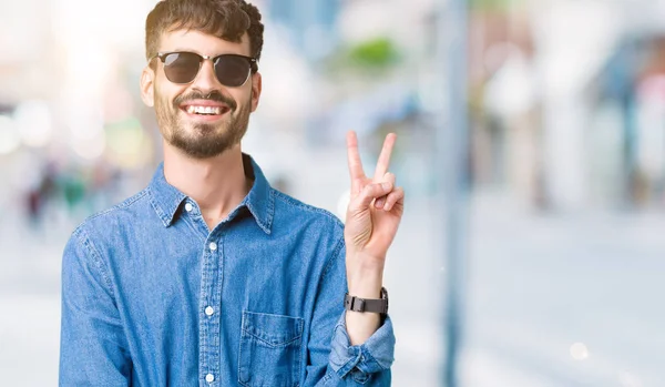 Homem Bonito Jovem Usando Óculos Sol Sobre Fundo Isolado Sorrindo — Fotografia de Stock