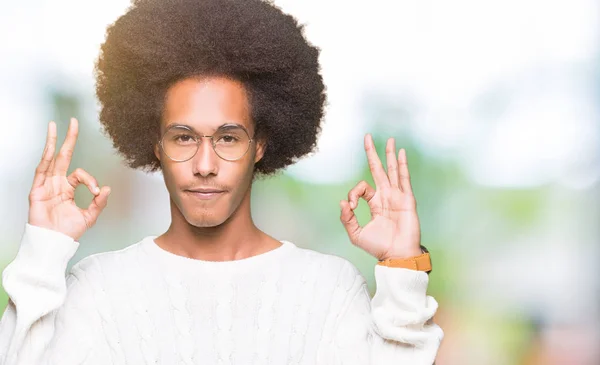 アフロ髪眼鏡の若いアフリカ系アメリカ人リラックスして瞑想の指ジェスチャーをやって閉じた目と笑顔します ヨガの概念 — ストック写真