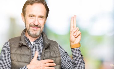 Orta yaş yakışıklı adam giyen kış göğüs ve bir sadakat sözü yemin yapma parmaklar, el ile Swearing yelek