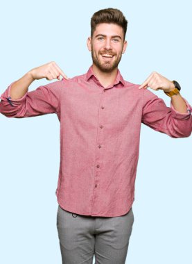 Yüzünde gülümseme ile kendinden emin görünüyorsun, kendini gururlu ve mutlu parmakları ile işaret genç yakışıklı iş casual adam.