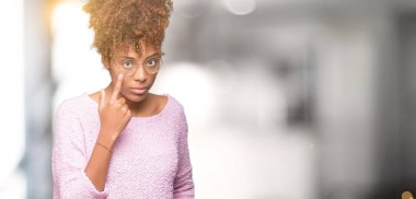 Güzel genç Afro-Amerikan kadın gözlük izole üzerinde arka plan işaret jest göz izlemek için şüpheli ifade