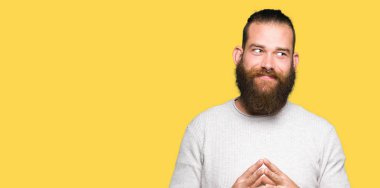 Casual kazak eller birlikte giyen genç sarışın adam ve parmakları rahat ve neşeli gülümseyen geçti. Başarı ve iyimser