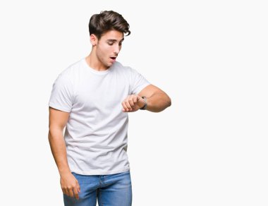 Arka plan üzerinde beyaz t-shirt giyen genç yakışıklı adam izole seyretmek zaman endişeli, geç korkuyor arıyorsunuz