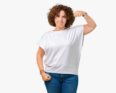 Kol kas, kendinden emin ve güç gurur gösteren izole arka plan güçlü kişi üzerinde beyaz t-shirt giyen güzel orta ager üst düzey kadın