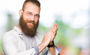 Genç sarışın adam gözlük giyen alkışlar ve mutlu ve neşeli alkışlar, gülümseyen gururlu eller birlikte