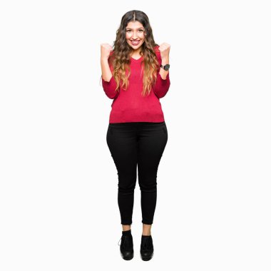 Kutlama kırmızı kazak giyen genç güzel kadın şaşırttı ve başarı için kaldırdı Kollarını açarak hayret ve gözleri açık. Kazanan kavramı.