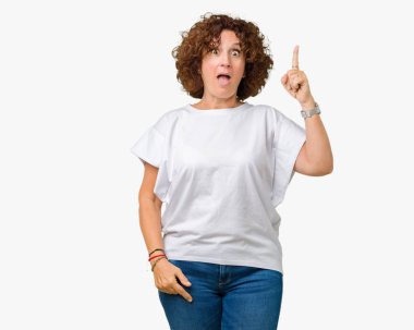 Başarılı fikirle izole arka plan işaret parmağı üzerinde beyaz t-shirt giyen güzel orta ager kadın kıdemli. Çıktıktan ve mutlu. Bir numara.
