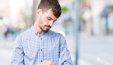 İzole arka planda genç yakışıklı iş adamı bilek saatindeki saati kontrol etme, rahat ve emin