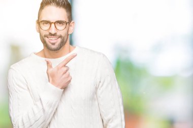 İzole arka neşeli bir gülümseme ile el ve parmak kadar yan yüzünde mutlu ve doğal ifade ile işaret yüz üzerinden gözlüklü genç yakışıklı adam
