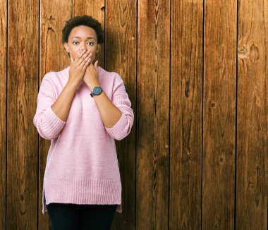 Güzel genç Afro-Amerikan kadın izole arka plan ağız hata için elleriyle kapsayan şok yüzünden. Gizli kavramı.