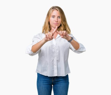 Beautiful young business woman over isolated background Rejection expression crossing fingers doing negative sign clipart