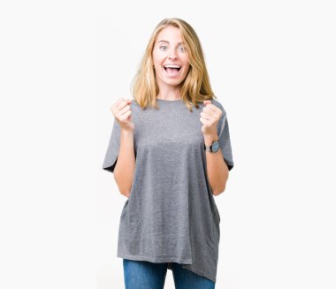 İzole arka plan kutlama üzerinde büyük boy rahat t-shirt giyen güzel ve genç birbayan şaşırttı ve başarı için kaldırdı kollarını açarak hayret ve gözleri açık. Kazanan kavramı.