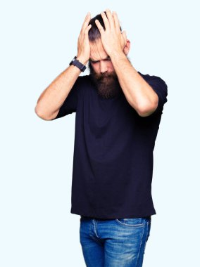Genç sarışın adam rahat t-shirt baş ağrısı çaresiz acı giyiyor ve çünkü ağrı ve migren vurguladı. Eller baş.