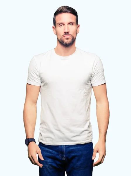 Pohledný Muž Nosí Ležérní Bílé Tričko Uvolněné Vážným Výrazem Tváři — Stock fotografie
