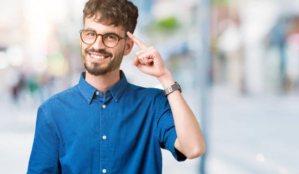 Pemuda Tampan Memakai Kacamata Atas Latar Belakang Terisolasi Tersenyum Menunjuk — Stok Foto