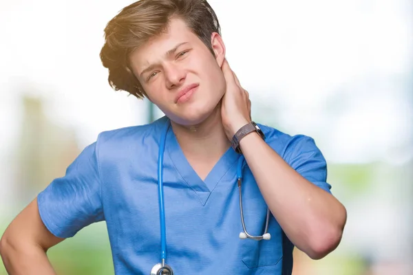 Jovem Médico Vestindo Uniforme Médico Sobre Fundo Isolado Sofrendo Lesão — Fotografia de Stock