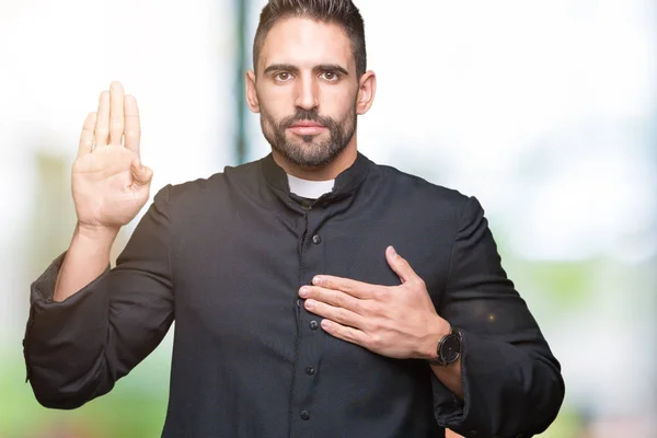 Jovem Padre Cristão Sobre Fundo Isolado Jurando Com Mão Peito — Fotografia de Stock
