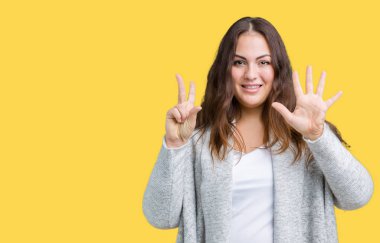Parmakları ile 7 ise kendinden emin ve mutlu gülümseyen güzel artı boyutu genç kadın giyiyor kış ceket ve yukarıyı gösteren izole arka plan üzerinde numara.