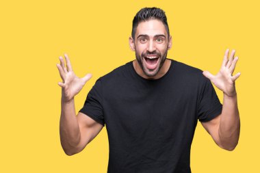 Yakışıklı delikanlı deli kutluyor ve silah ile başarı için heyecanlı çığlık kaldırdı ve açık gözleri hayret izole arka plan üzerinde. Kazanan kavramı