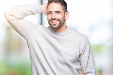 Kazak hareketi el ile kendine güvenen dokunaklı saç gülümseyerek, çekici poz izole arka plan üzerinde giyen genç yakışıklı adam