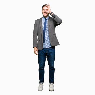 Yakışıklı iş adamı giyen takım elbise ve gülümseyen, parmakları ile mutlu yüz üzerinden seyir göz el ile ok jest yapıyor kravat.