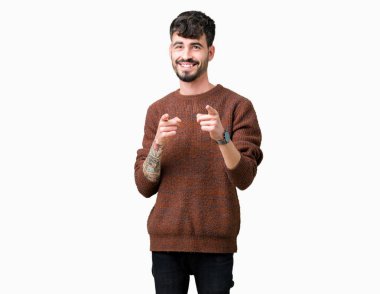 Fotoğraf makinesi ile mutlu ve komik yüz için parmakları işaret izole arka plan üzerinde kış kazak giyen genç yakışıklı adam. İyi enerji ve vibes.