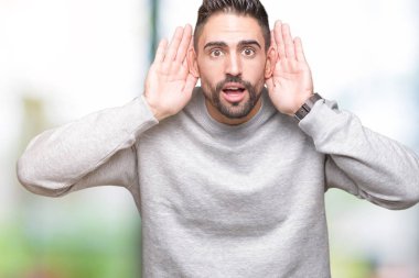 Her ikisi de dinliyoruz izole arka plan üzerinde sweatshirt giyen genç yakışıklı adam kulak jest, dedikodu için meraklı eller. İşitme sorunu, sağır