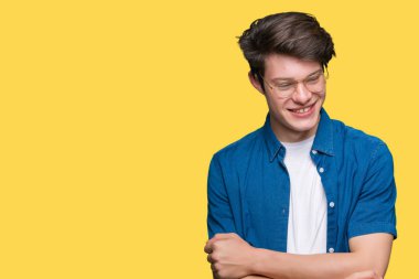 Yakışıklı delikanlı üzerinde gözlük takan mutlu yüz ile gülümseyerek kameraya seyir silah geçti arka plan izole. Olumlu bir kişi.